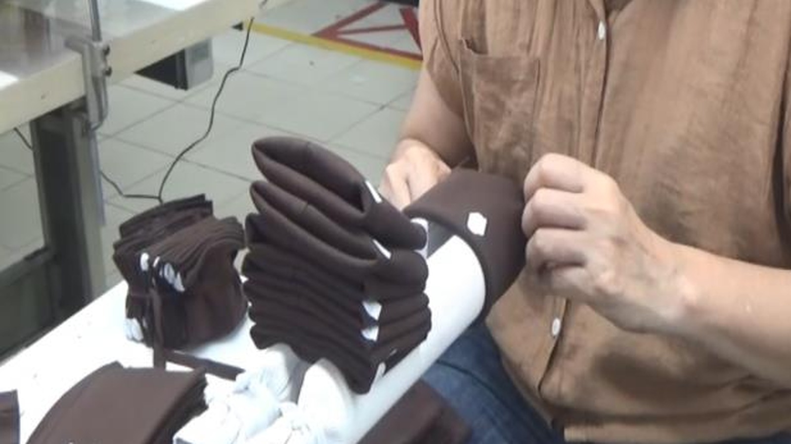 Operator handling sleeve cuff parts during a garment factory method improvement review